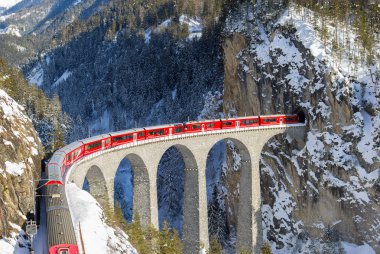 Filisur, İsviçre - 19 Ocak. 2019: kırmızı yolcu Swiss tren Landwasser Viyadüğü üzerinde hangi IA İsviçre dağ demiryolu merak 1901 yılında ve 2008 yılından bu yana unesco miras harikası geçen.