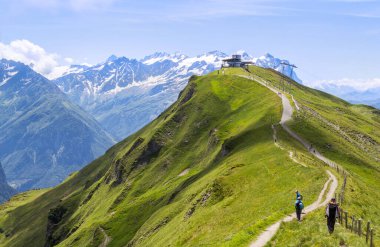 Haslital Vadisi 'ndeki yürüyüş cennetinin arka planında Rosenlaui Buzulu ve Wetthorn ile birlikte 2,245 metre yüksekliğindeki zirvenin tepesindeki panorama restoranı Alps Tower..