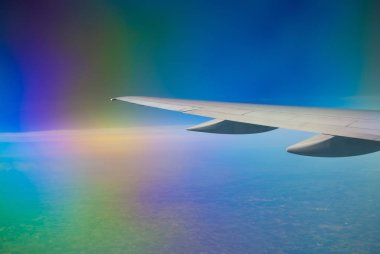 Gökkuşağı gökyüzü arka plan resmi olarak bir soyut uçak kanadı.