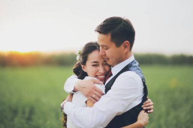 Mutlu gelin ve damat gün batımında parkta birbirlerine sarılırlar. Düğün için. Mutlu aşk konsepti. Yüksek kalite fotoğraf