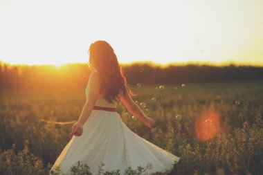 Gün batımında parkta dans eden güzel kız. Sabun köpükleri. Mutluluk kavramı. Yüksek kalite fotoğraf