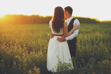 Mutlu gelin ve damat gün batımında parkta birbirlerine sarılırlar. Düğün için. Mutlu aşk konsepti. Yüksek kalite fotoğraf