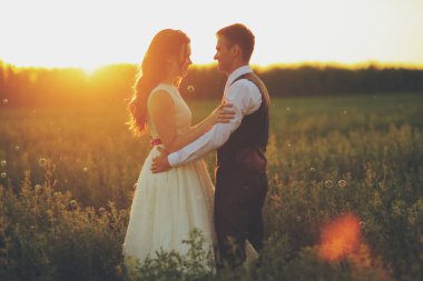 Mutlu gelin ve damat gün batımında parkta birbirlerine sarılırlar. Düğün için. Mutlu aşk konsepti. Yüksek kalite fotoğraf