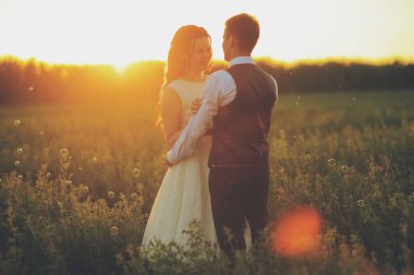 Mutlu gelin ve damat gün batımında parkta birbirlerine sarılırlar. Düğün için. Mutlu aşk konsepti. Yüksek kalite fotoğraf