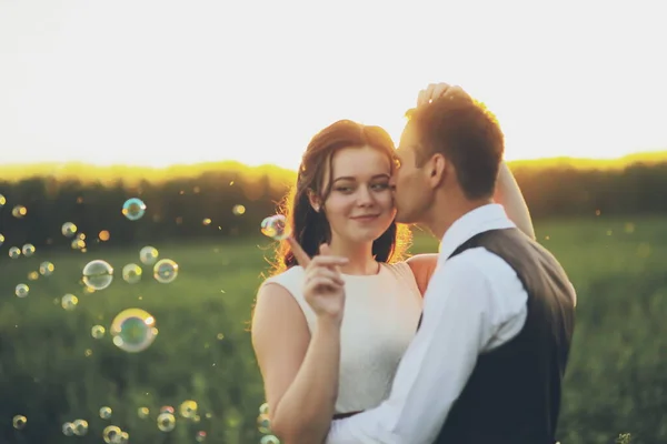 Gli Sposi Felici Abbracciano Nel Parco Tramonto Bolle Sapone Matrimonio — Foto Stock