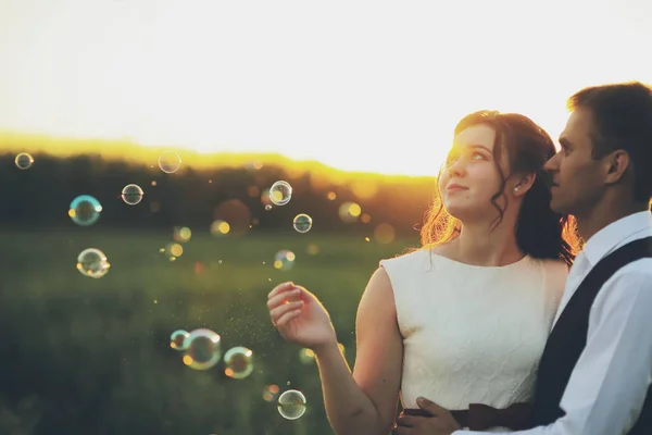 Gli Sposi Felici Abbracciano Nel Parco Tramonto Bolle Sapone Matrimonio — Foto Stock