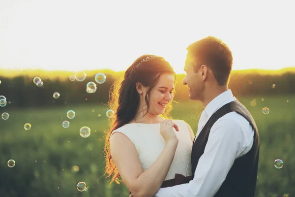 Gli Sposi Felici Abbracciano Nel Parco Tramonto Bolle Sapone Matrimonio — Foto Stock