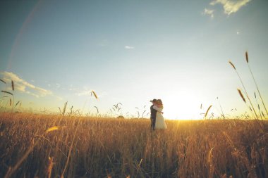 Mutlu gelin ve damat gün batımında parkta birbirlerine sarılırlar. Düğün için. Mutlu aşk konsepti. Yüksek kalite fotoğraf