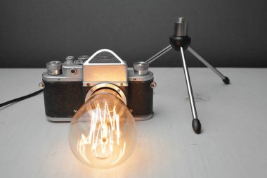 Gri arka planda Edison lambası olan eski bir kameradan alınmış gaz lambası. Kavram iyi bir fikir. Yüksek kalite fotoğraf
