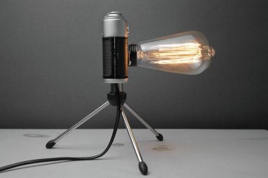 Gri arka planda Edison lambası olan eski bir kameradan alınmış gaz lambası. Kavram iyi bir fikir. Yüksek kalite fotoğraf