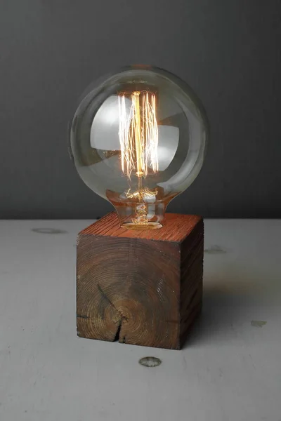 Retro wood lamp with Edison lamp on a gray background. The concept is a good idea. High quality photo