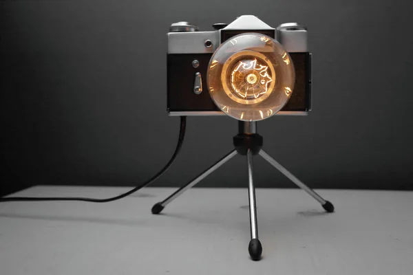 Retro lamp from an old camera with an Edison lamp on a gray background. Concept is a good idea. High quality photo