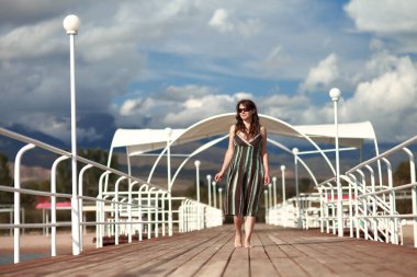 Genç kadın rıhtımdaki sahilde dinleniyor. Tatil Seyahat Konsepti. Yüksek kalite fotoğraf