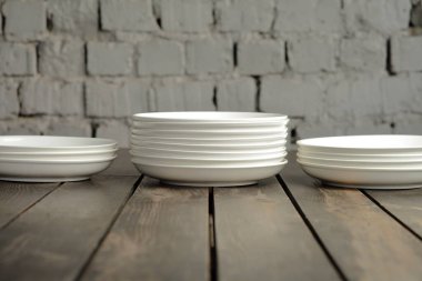 Ahşap bir çatı katında boş beyaz tabak. Yüksek kaliteli fotoğraf.