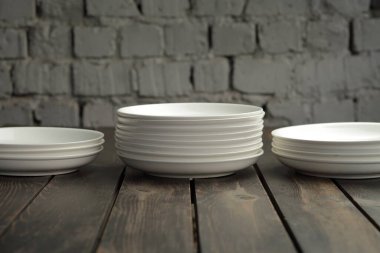 Ahşap bir çatı katında boş beyaz tabak. Yüksek kaliteli fotoğraf.