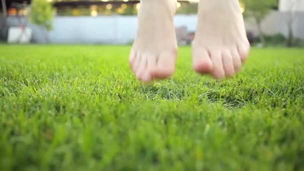 Ноги женщины, девушки прыгают по зеленой лужайке — стоковое видео