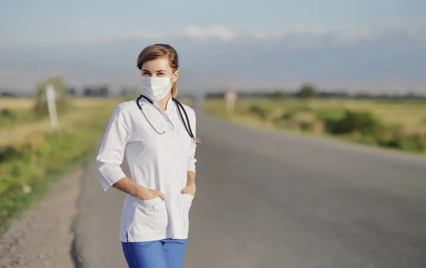 Vrouwelijke Arts Verpleegkundige Met Een Beschermend Gezichtsmasker Naast Een Landelijke — Stockfoto