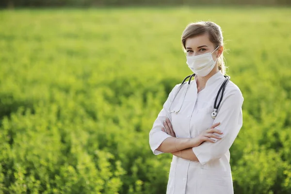 Vrouwelijke Arts Verpleegkundige Met Een Beschermend Gezichtsmasker Groene Grasondergrond Veiligheidsmaatregelen — Stockfoto