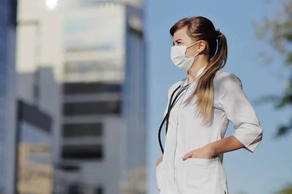 Vrouwelijke Dokter Verpleegster Met Een Beschermend Gezichtsmasker Stad Een Wolkenkrabber — Stockfoto