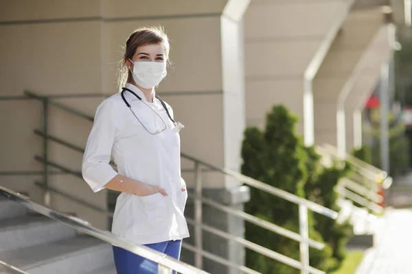 Confident female doctor or nurse wearing a face protective mask. Safety measures against the coronavirus. Prevention Covid-19 healthcare concept. Stethoscope over the neck. Woman, girl.