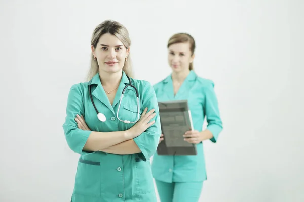 Két női orvos vagy nővér nézi a kamerát. sztetoszkóp a nyakon — Stock Fotó