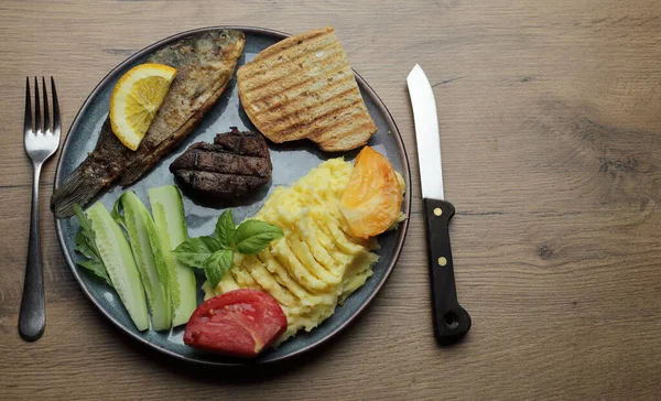 油炸鱼 肉排和蔬菜放在盘子里 在一张木制桌子上高质量的照片 — 图库照片