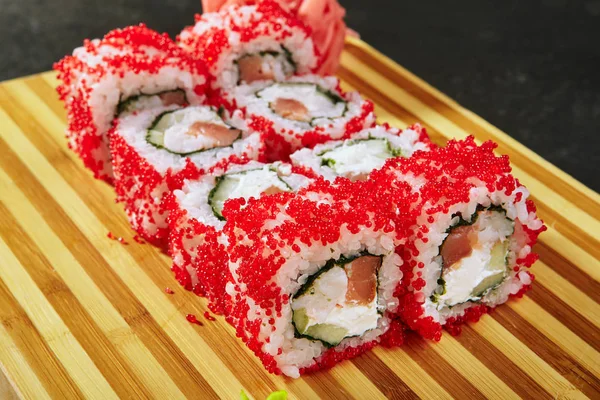 Asya menüsü. Masago havyarlı suşi sarması. Somon, karides ve salatalık.