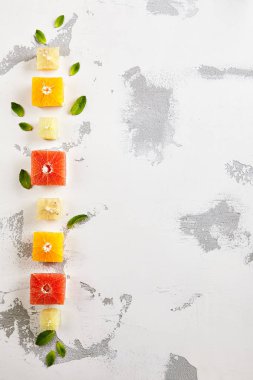 Taze narenciye - küp dilim portakal, Grapeftuit ve kireç. Yaratıcı yaz meyve düzeni. Üstten görünüm
