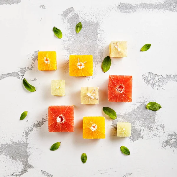 Taze narenciye - küp dilim portakal, Grapeftuit ve kireç. Yaratıcı yaz meyve düzeni. Üstten görünüm