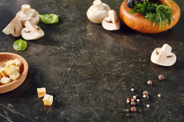 Beyaz Champignon mantar karanlık taş plaka arka plan dereotu, fesleğen, karabiber ve Croutons. Tarifi şablonu için otlar ile bütünleşmiş ve dilimlenmiş mantar