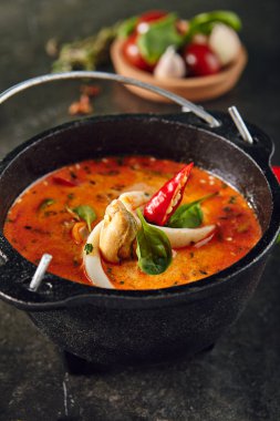 Tom Yum veya Tom Yam kalamar, karides, Chili biber, limon suyu, havlıcan, balık sosu, limon. Sıcak ve ekşi Tay çorba kokulu baharatlar ile pişirilir. Koyu arka plan üzerinde geleneksel Tayland Gıda
