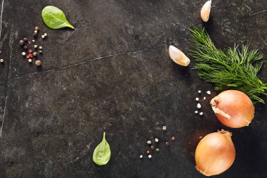 Taş koyu arka plan ampuller, kruton, sarımsak, dereotu, karabiber, ıspanak ve tuz. Tarifi şablon seçici odak için dağınık baharat ile karanlık kayrak çerçeve