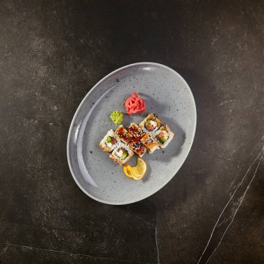 Kanada suşi rulo somon balığı, yılanbalığı, Philadelphia peynir, avokado ve salatalık ile ahşap tabak üzerinde servis. Asya menü