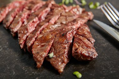 Sıcak ızgara bütün pala biftek ya da etek biftek siyah taş zemin üzerine kalın dilim. Taze sulu Orta nadir sığır eti Grillsteak. Barbekü et en iyi görünümü Kapat