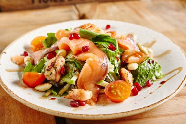 Somon salata karides ve yeşil karışımı. Marul, salatalık, Radicchio, fındık, nar, kiraz domates ve sos ile füme alabalık ince dilim. Kırmızı balık ham tuzlu barışlar yakın çekim