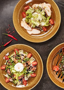 Rustik seramik kaplamalar üstten görünüm çeşitli et salata kümesi. Füme Türkiye'de tatlı sosu, pastırma, haşlanmış yumurta, Dana bonfile, Zeytinyağlı ve balsamik giymiş sedir fındık karışımı salata