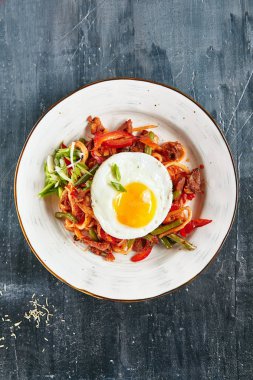 Ev yapımı Kaurma Lagman veya sebze, sığır eti ve oryantal baharatlar ile Laghman kapatın. Zengin Asya yemek yumurta üstten görünüm ile hizmet kılçıklı bir hamur hazırlanmış Fried ev yapımı erişte