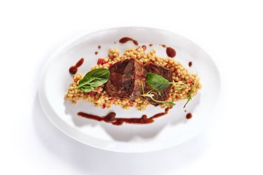 Dana Bonfile Ptitim ile veya kuş ve beyaz arka plan üzerinde izole Parmesan peyniri. Restoran Ana Kursu ile Dana eti, İsrail kuskus, Brown Sause ve yeşillik üst görünümü