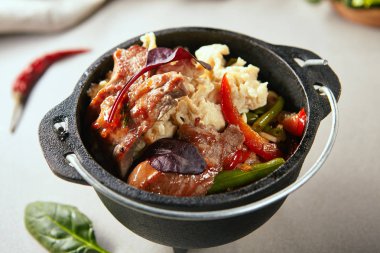 Yakın çekim yemek Asya tarzı dikey portresi. Yeşil yükselişiyle sığır eti ve Japon omlet karanlık tencereye hizmet fasulye. Seçici odak. Arka plan bulanık