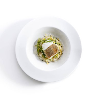Lezzetli pike levrek risotto ile yakın çekim portre. Biraz hava espoume ile taze kabak mükemmel tadı ile servis. Beyaz arka plan üzerinde izole