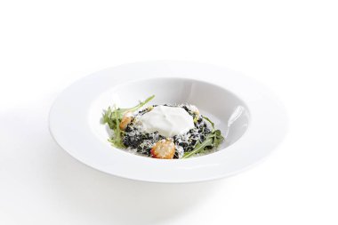 Yakın çekim portre siyah risotto ile mürekkep balığı mürekkep tarak ve espoume. Aromatik otlar ile yemek. Deniz ürünleri kavramı. Beyaz arka plan üzerinde izole