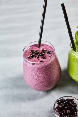 Yakın çekim resim smoothy sulu bilberry muz ve lezzetli yoğurt ile cam. Mor soğutma içecek. Yaz içki kavramı. Gri arka plan üzerinde izole
