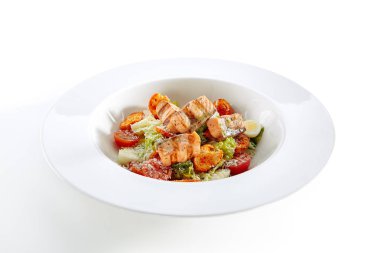 Zarif restoran izole plaka üzerinde ızgara somon ile Sezar salatası. Salat kırmızı balık fileto, Bıldırcın yumurta, Mini baget kraker, Cherry domates, marul yaprakları, Sezar sos ve Parmesan peyniri ile