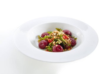 Greyfurt çam fıstığı ve beyaz arka plan üzerinde izole pancar hemisferlerin ile garnitür roka salatası. Restoran zarif servis tabağı meyve ve sebze Salat ile yakın çekim