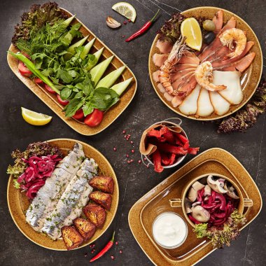 Soğuk meze koleksiyonu ile taze sebze, tuzlu balık, fırında patates, salamura mantar ve karides üstten görünüm. Çeşitli deniz ürünleri, meze ve Yeşiller düz Lay ile Restoran açık büfe