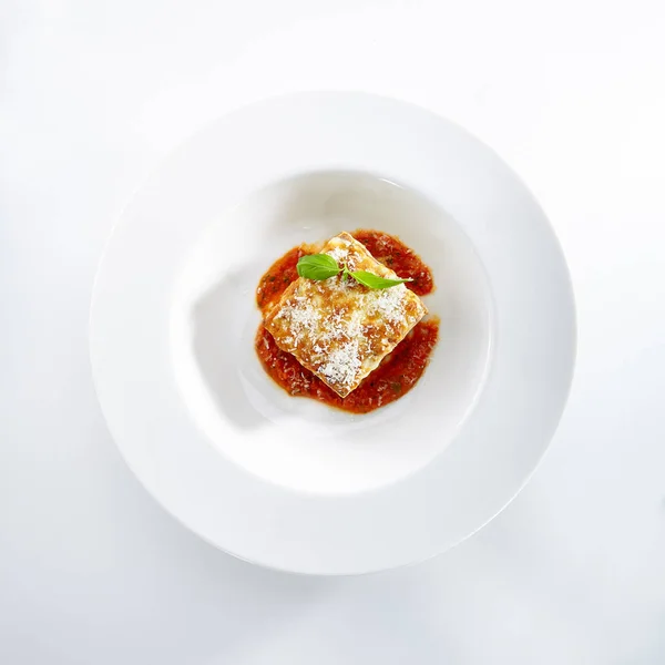 伝統的な自家製イタリアのラザニアと白い背景で隔離のトマトソース 熱いおいしいラザニアやエレガントなレストラン プレート上面にパルメザン チーズとラザニア — ストック写真