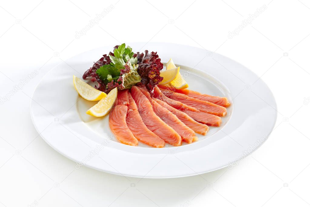 Restaurant Starter Menu with Slightly Salted Salmon Fillet Isolated on White Background. Thin Slices of Red Fish or Trout with Lemon and Greens on Elegant Flat Plate Close Up
