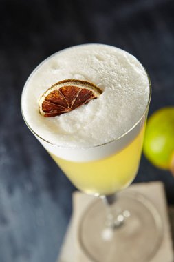 Pisco ekşi taze sıkılmış limon suyu, basit tatlı şurup, buz, yumurta beyaz ve siyah arka plan üzerine Angostura Bitters ile. Soğuk Perulu alkollü kokteyl kadar yakın