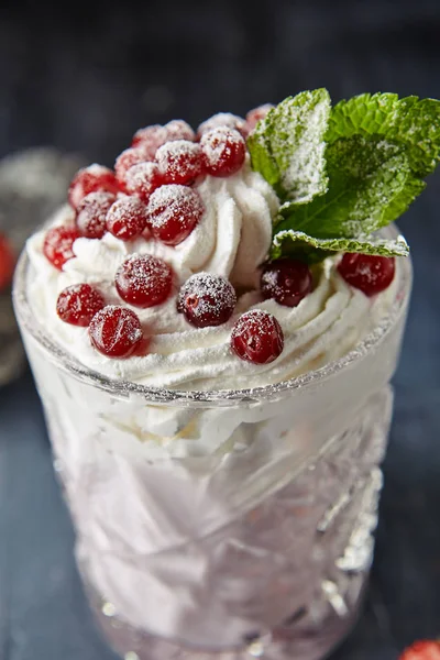 Restaurant Served Warm Cocktail with Berries and Whipped Cream on Black Background. Macro Photo of Blueberry, Blackberry, Cranberry and Strawberry Milkshake in Elegant Glass Close Up