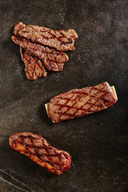 Barbekü ızgara arka plan üzerinde sıcak taze Gaucho Steak ve kanat Steak. Beef ve Iyi bitmiş Barbekü Entrecotes ile Tri-ipucu Grillsteak yemeye hazır. Kemik üst görünümü ile kızarmış et kalın dilimleri